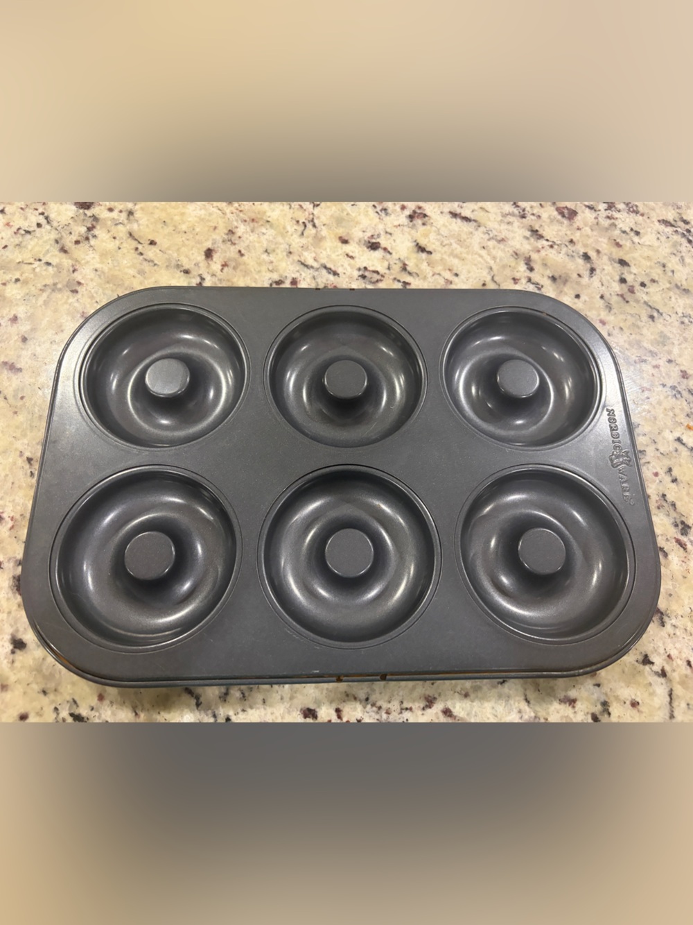Nordic Ware Silver Donut Pan featuring a metallic gray, six-cavity nonstick pan